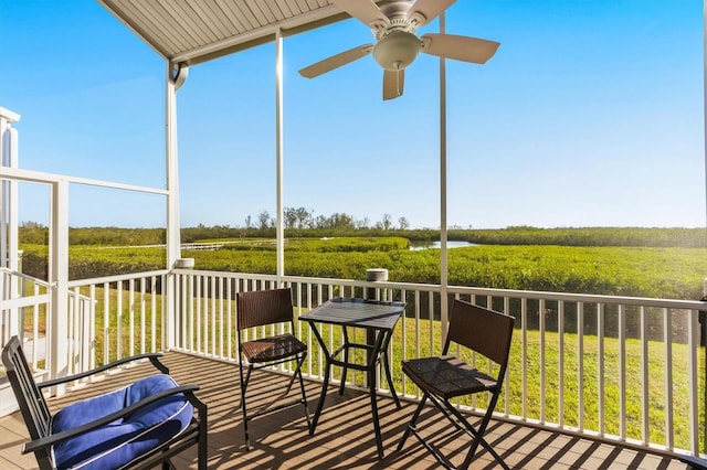 sunroom / solarium with ceiling fan and a rural view