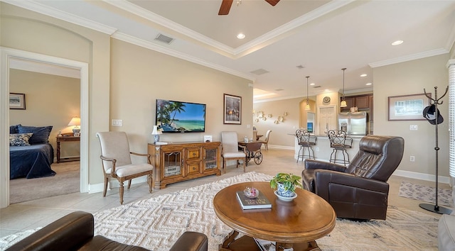 living room featuring light tile patterned floors, a tray ceiling, ceiling fan, and ornamental molding