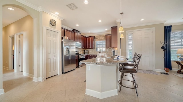 kitchen with light tile patterned floors, light stone countertops, hanging light fixtures, and appliances with stainless steel finishes