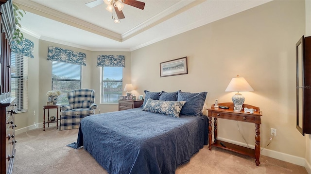 carpeted bedroom featuring a raised ceiling, ceiling fan, and crown molding