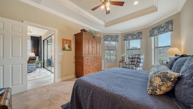 carpeted bedroom featuring ceiling fan, crown molding, and a tray ceiling