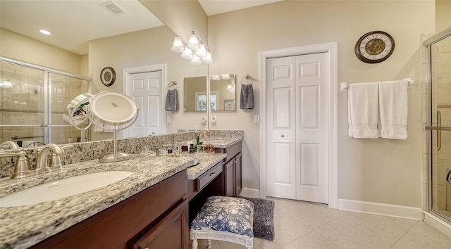 bathroom featuring tile patterned floors, vanity, and a shower with shower door