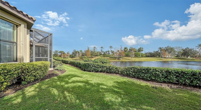 view of yard featuring glass enclosure and a water view