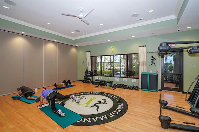 exercise room with hardwood / wood-style floors, ceiling fan, and ornamental molding