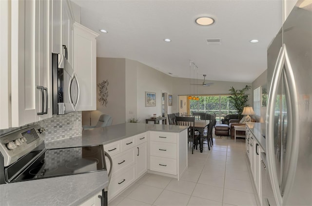 kitchen featuring stainless steel appliances, light tile patterned floors, backsplash, kitchen peninsula, and white cabinets