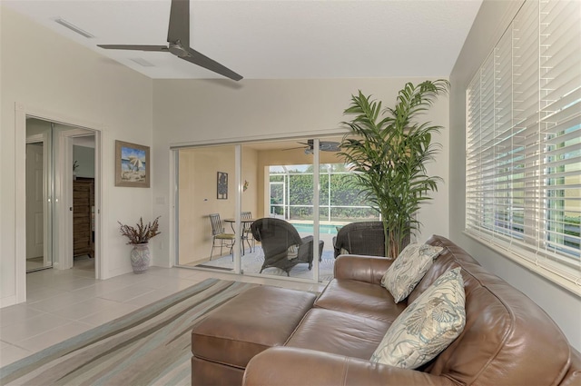 living room with ceiling fan, light tile patterned flooring, and vaulted ceiling