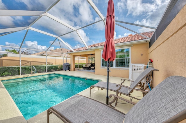 view of swimming pool featuring a lanai, ceiling fan, and a patio area