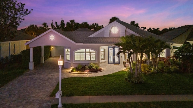 view of front of home with a yard, french doors, and a carport