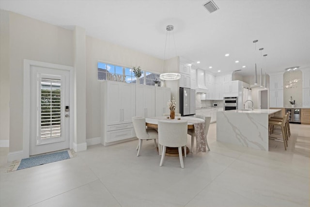 tiled dining room with wine cooler and sink