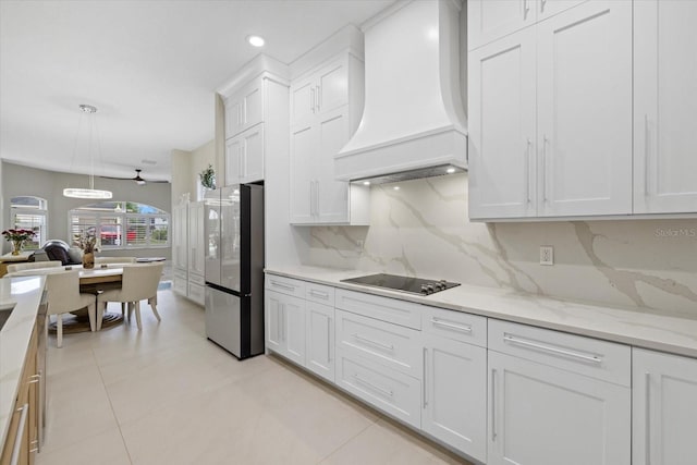 kitchen with white cabinets, decorative backsplash, stainless steel refrigerator, and custom exhaust hood