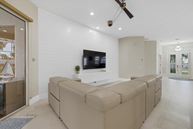 tiled living room with ceiling fan and french doors