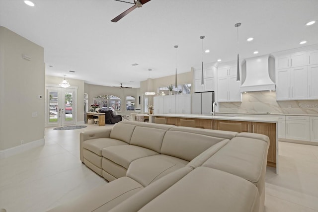 living room featuring ceiling fan, french doors, and sink