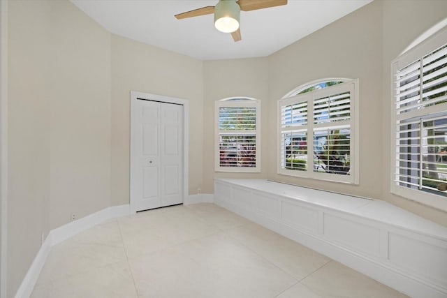 tiled empty room featuring ceiling fan