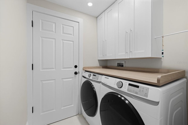 laundry room with cabinets and washing machine and clothes dryer