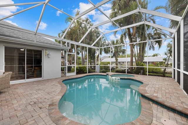 view of swimming pool with an in ground hot tub, a lanai, and a patio area