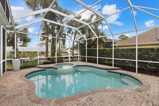 view of swimming pool with glass enclosure, a patio area, and an in ground hot tub