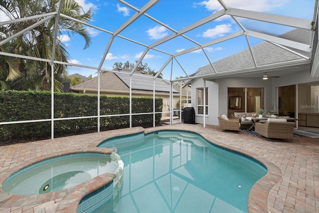 view of swimming pool with outdoor lounge area, glass enclosure, an in ground hot tub, and a patio area