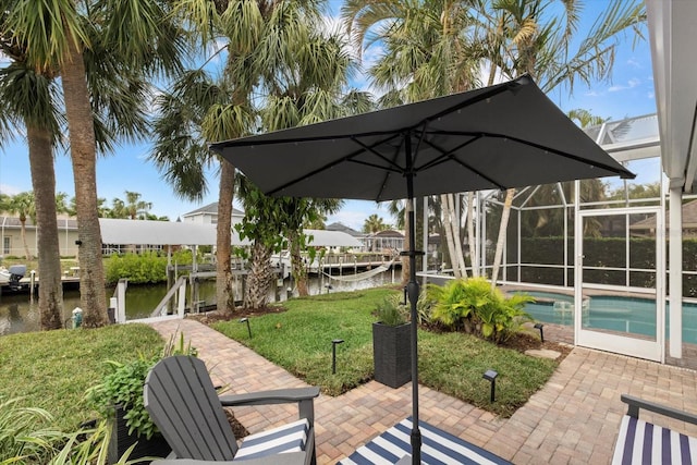 view of patio with a lanai, a dock, and a water view