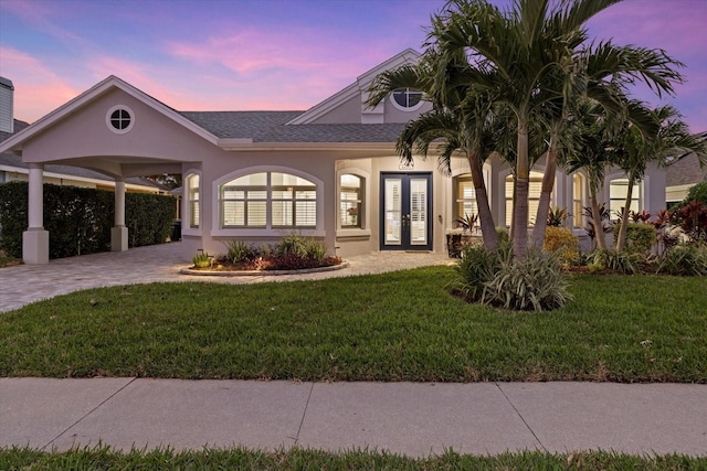 view of front of home with a yard and french doors