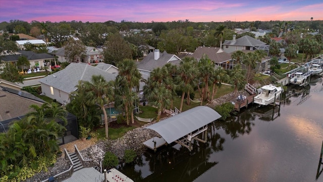 aerial view at dusk featuring a water view