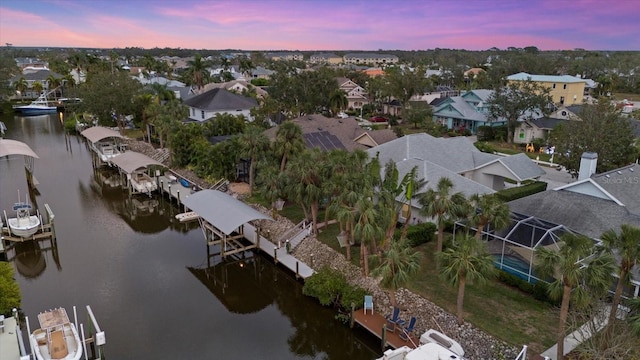 aerial view at dusk featuring a water view