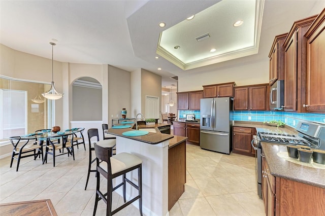 kitchen featuring decorative backsplash, light tile patterned floors, a raised ceiling, and stainless steel appliances