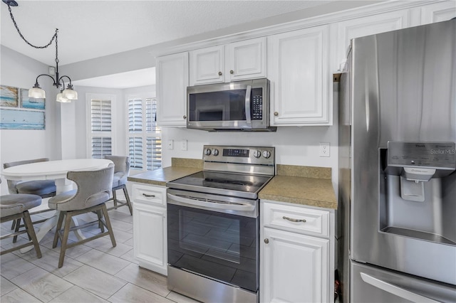 kitchen featuring an inviting chandelier, white cabinets, pendant lighting, and appliances with stainless steel finishes