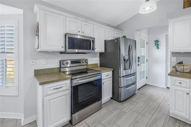 kitchen with white cabinets, appliances with stainless steel finishes, vaulted ceiling, and hanging light fixtures