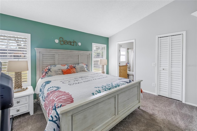 carpeted bedroom with a textured ceiling, ensuite bathroom, and vaulted ceiling