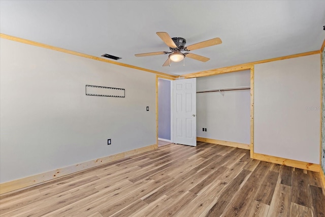 unfurnished bedroom with crown molding, a closet, ceiling fan, and hardwood / wood-style floors