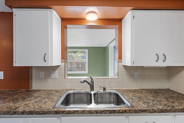 kitchen with decorative backsplash, white cabinetry, and sink