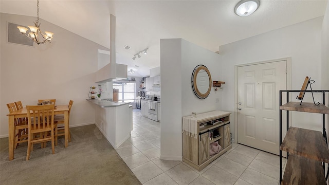 interior space featuring a chandelier, pendant lighting, electric range, and light tile patterned floors