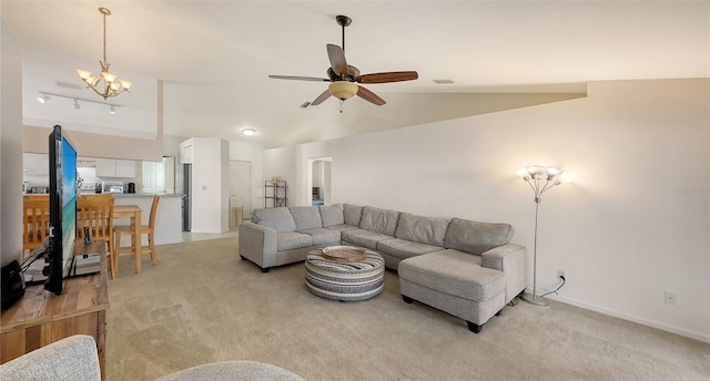 carpeted living room with ceiling fan with notable chandelier and vaulted ceiling