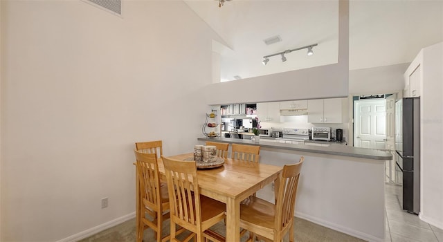 dining area featuring lofted ceiling and light carpet