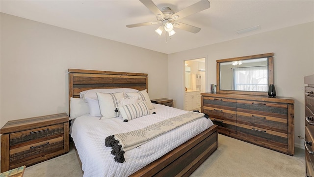 carpeted bedroom featuring ceiling fan and ensuite bath