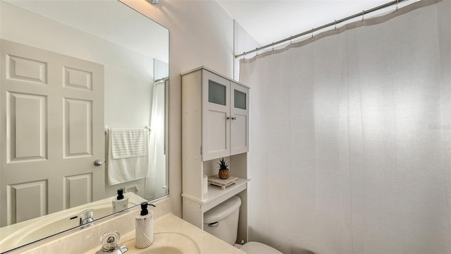 bathroom featuring a shower with curtain, vanity, and toilet