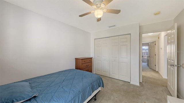 carpeted bedroom featuring ceiling fan and a closet