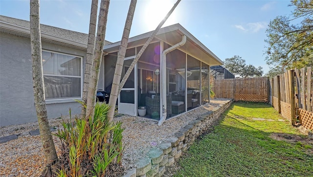 view of side of home with a yard and a sunroom