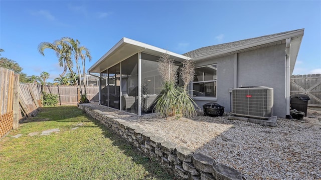 back of house with a sunroom, central air condition unit, and a yard