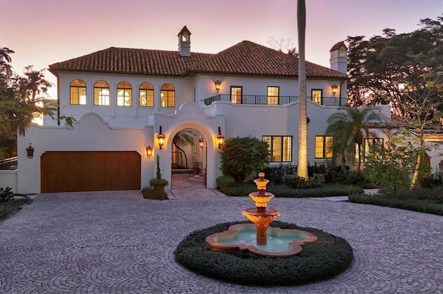 mediterranean / spanish home featuring a balcony and a garage