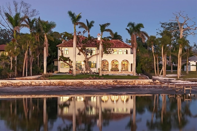 back of property with a balcony and a water view