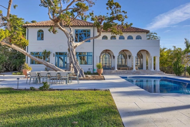 back of house with a yard and a patio