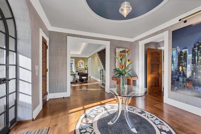 entryway featuring french doors, a raised ceiling, ornamental molding, and hardwood / wood-style floors