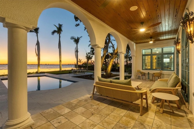 exterior space featuring ceiling fan and a water view