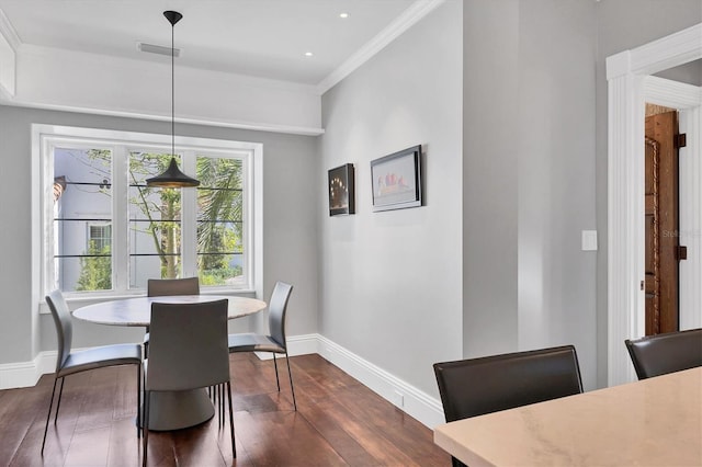 dining area with crown molding and dark wood-type flooring