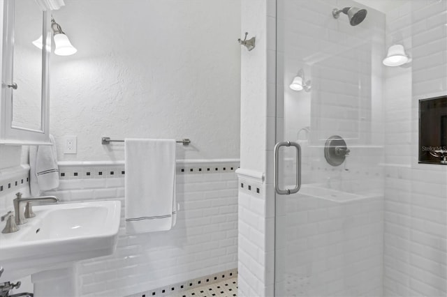 bathroom featuring tile walls, sink, and an enclosed shower