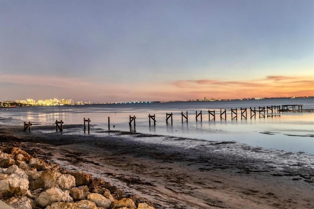 dock area featuring a water view and a beach view