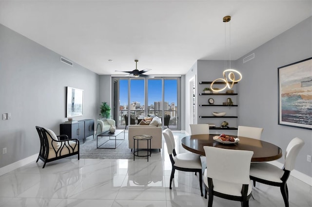 dining area featuring ceiling fan and a wall of windows