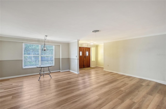 spare room with ornamental molding and light hardwood / wood-style floors