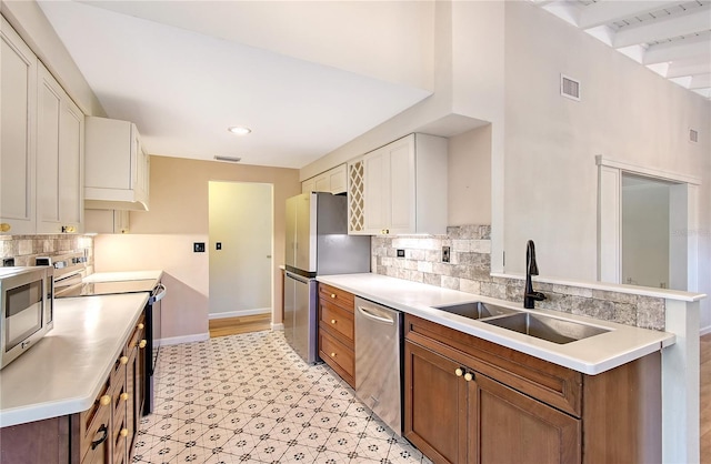 kitchen featuring sink, decorative backsplash, white cabinets, and appliances with stainless steel finishes